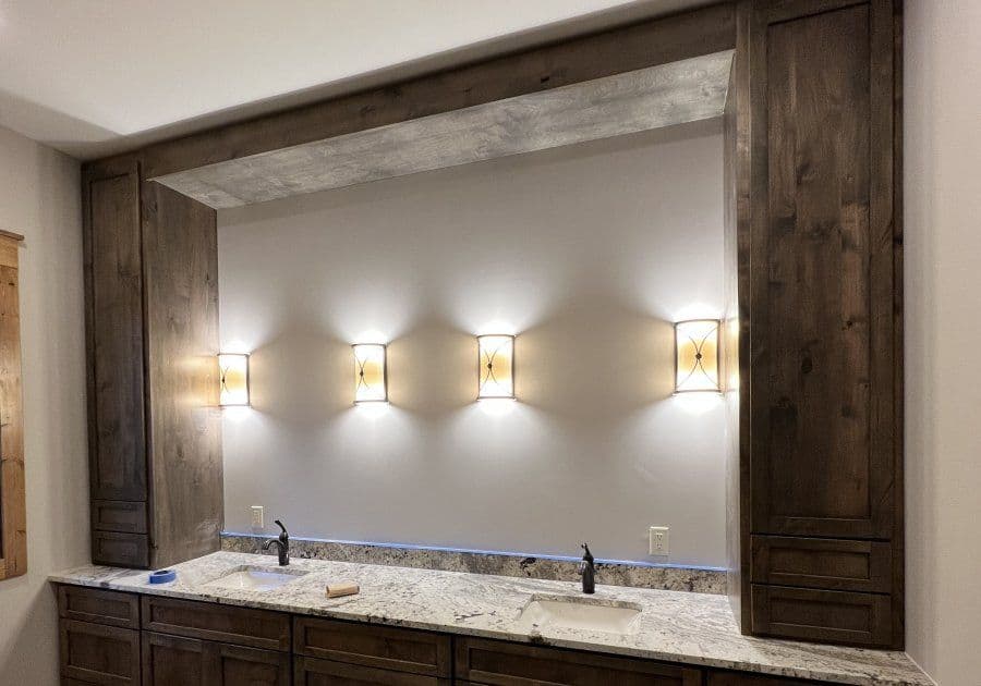 Modern bathroom vanity with granite countertop and stylish wall-mounted lights.